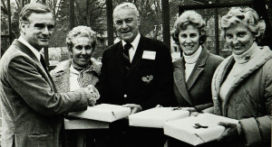 At the FMTC Centennial Celebration, Club President Charlie Evans presents awards to all-time winners Madge Beck and Dick Hebard. Molly Ware and Do Deland received awards for their fathers, Blanchard and Cogswell.